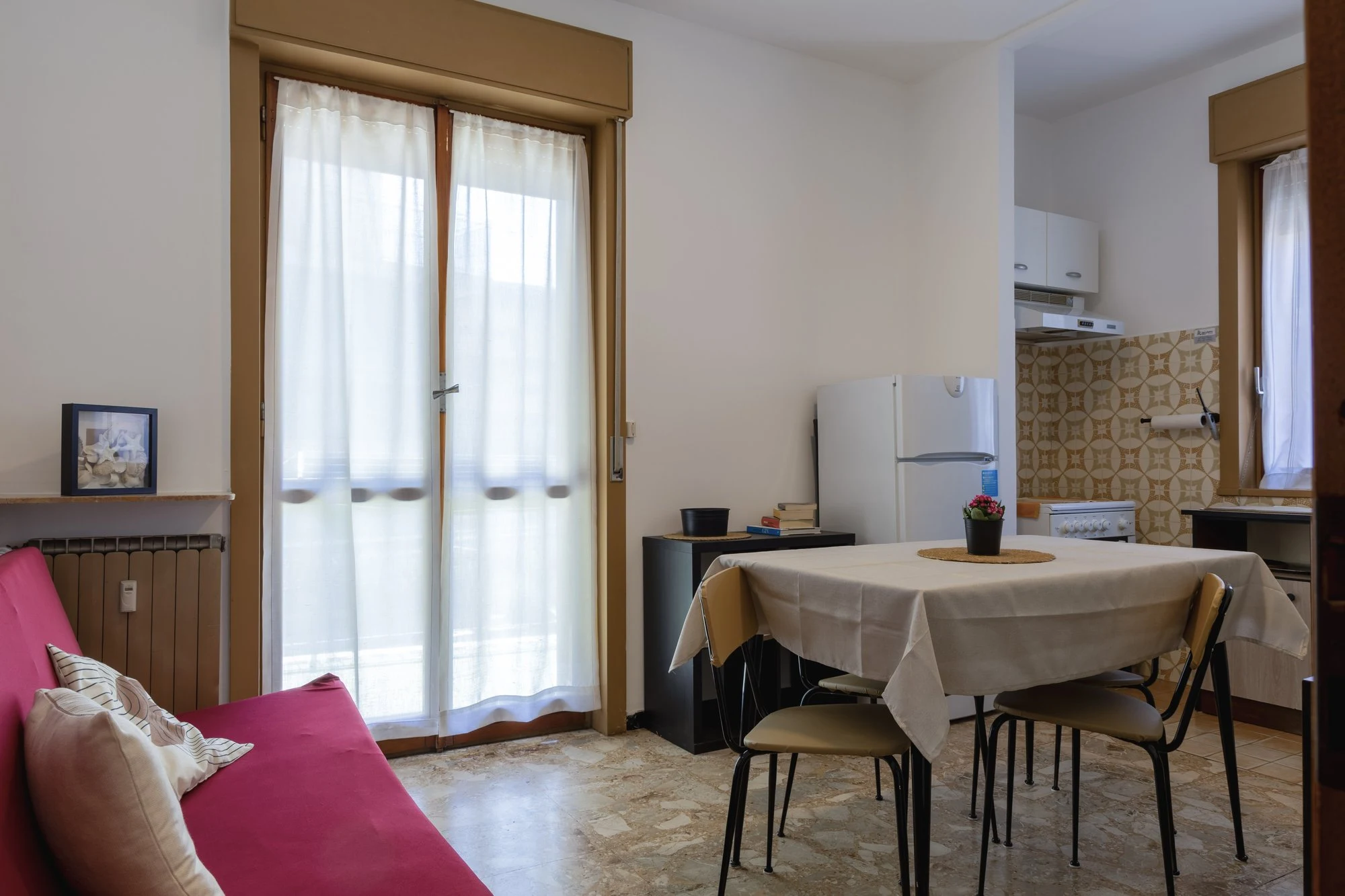 Soggiorno di Magnolia con tavolo da pranzo, divano e cucinino